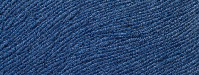 Texture of navy blue woolen textile background from soft wool material, macro. Structure of denim...