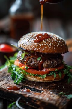 Large hamburger with pickles and pickle juice, on a wooden board against a dark background