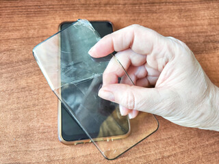 Removing Protective Film From a Cracked Screen. Peeling off a cracked screen protector from a phone