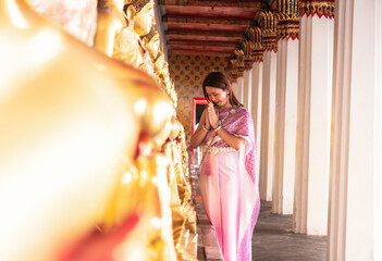 Tourist Asian woman wearing Thai national costume comes to visit an old church, touring an old...