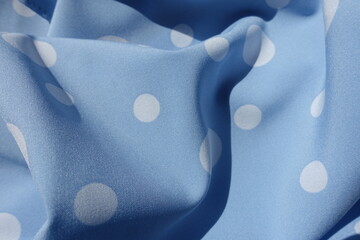 Soft folds on light blue rayon fabric with polka dot pattern
