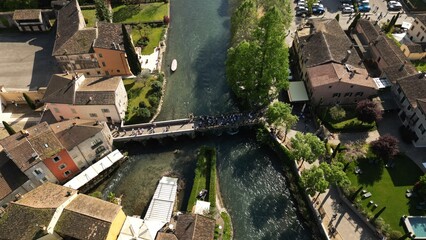 Naklejka premium Top view of the mill village of Borghetto sul Mincio in the south of Lake Garda, in Veneto, Italy. Drone footage of the small medieval village.