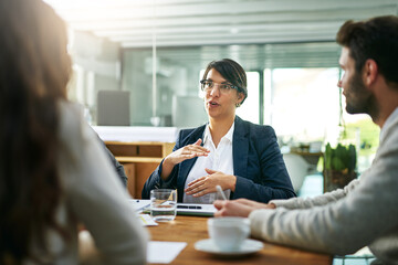 Obraz premium Explain, talking or businesswoman in meeting for planning, collaboration or teamwork with people at office. Group, speaking or consultant with strategy for discussion, conversation or feedback review