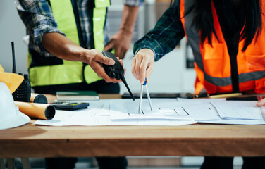 Engineer teams meeting working together wear worker helmets hardhat on construction site in modern city.Asian industry professional team..