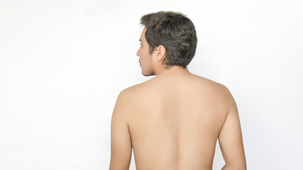 Back view of a shirtless young adult man, looking to the left, with space for text on the left, against a white background. - obrazy, fototapety, plakaty