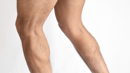 Muscular legs of a man, calves of both feet seen from the side, with a white background and space...