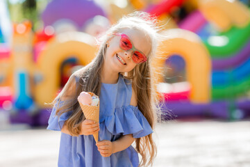 happy little girl eats ice cream in the park in the summer