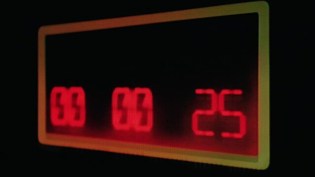 Real TV capture: a shaky countdown timer, red LCD numbers going down to zero on a big display. Concepts: danger, deadline, terrorism; or the new year coming.