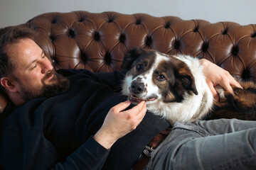Man sitting on the sofa with his dog.