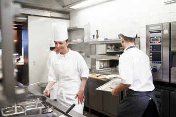 Man, woman and cooking in industrial kitchen or chef with food for dinner rush, hospitality or fine...