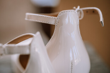 Valmiera, Latvia - August 19, 2023 - Close-up of elegant white high-heeled bridal shoes with a...