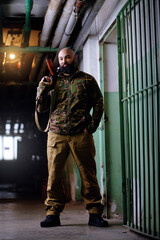 Portrait of the armed bearded man looking with a serious face straight at the camera