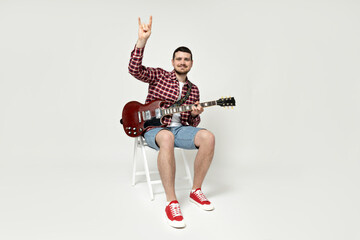 Attractive young guy playing the guitar on a white background