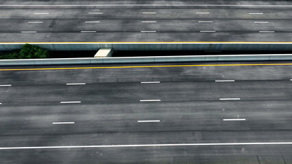Drone aerial view : An epic intercity motorway unfolds, deserted, a symphony of asphalt. Captured by a drone, it snakes through the landscape, an empty canvas for future journeys. Road background. 
