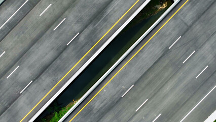 Drone aerial view : An epic intercity motorway unfolds, deserted, a symphony of asphalt. Captured by a drone, it snakes through the landscape, an empty canvas for future journeys. Road background. 
