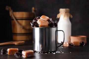 Cubes of salted caramel in a metal cup with milk in a bottle