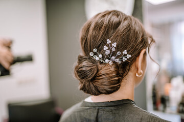 Valmiera, Latvia - August 19, 2023 - Elegant hairstyle with a decorative hair accessory adding a...