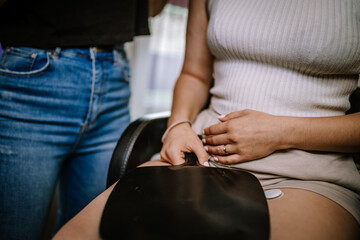 Valmiera, Latvia - August 19, 2023 - Close-up of a hairstylist's hands holding a client's hand during a consultation in a salon.