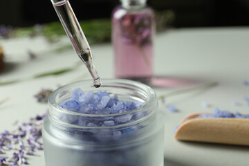 A dropper with lavender oil and a lavender flower close-up