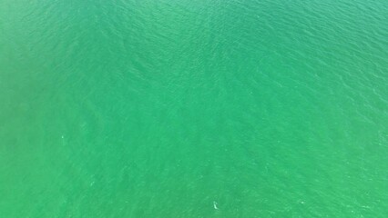 The tranquil sea waves, as seen from above by a drone, where the water's gentle caress soothes the...
