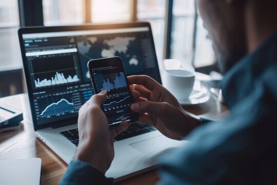 business, technology, internet and people concept - close up of man with laptop computer and smartphone with stock market chart on screen over office background - Powered by Adobe