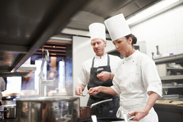 Chef, teamwork and cooking in kitchen at stove or preparation of food for fine dining, cuisine or...