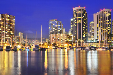 Obraz premium Night lights of Honolulu's Ala Wai Boat Harbor on the Island of Oahu, Hawaii. 