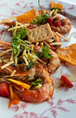 Close up of a plate of prawns with romesco sauce. vertical image