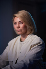 A woman in a white jacket smiles for the camera in formal wear