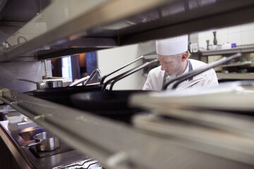 Cooking, chef and man in kitchen at restaurant for fine dining, service or hospitality industry....