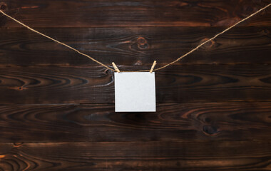 paper card hanging on the rope on wooden background