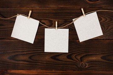 3 Note paper cards hanging with wooden clip or clothespin on rope string peg on wooden background