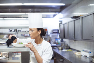 Cooking, chef and woman in kitchen for dinner preparation, plating dish and fine dinning with...