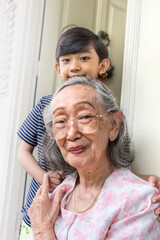 Healthy and happy Asian grandmother posing together with her grandson