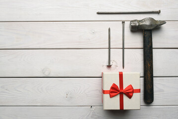 Labor day or father day concept background. Present gift box and work tool on the white workbench...
