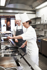 Chef, team and cooking with pan in kitchen for restaurant or hospitality industry, roasting and fry...