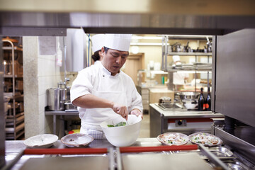 Asian man, chef and food service for restaurant with catering industry, uniform and fine dining for nutrition. Male employee, hospitality and cuisine in kitchen for menu, cooking career and dinner