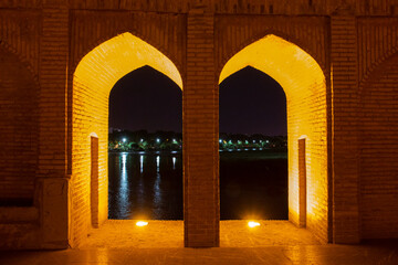 Obraz na płótnie Canvas the beautiful view of the city of Isfahan and the zayandeh rud River at night and the thirty-three bridge (siose pol) of this city, which have a special view at night with lighting
