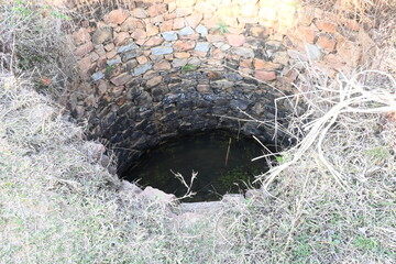 Old water well.  It is common to see these wells in the fields of India.  Earlier, it was used for farming. This well is made of stones.