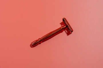 Metal razor on a pink background. Razor close-up.