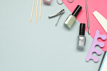Nail polishes and set of pedicure tools on color background, flat lay. Space for text