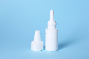 Bottle of medical drops on light blue background, space for text