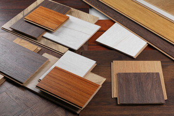 Many different samples of wooden flooring on table