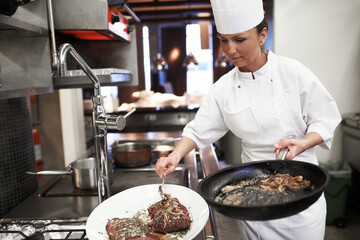 Chef, steak and woman fry in kitchen of restaurant for dinner, lunch or supper with hospitality....