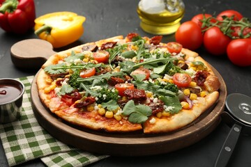 Delicious vegetarian pizza, ingredients and cutter on black table