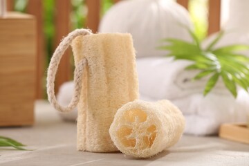 Natural loofah sponges on grey textured table