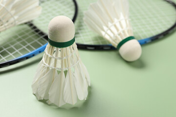 Feather badminton shuttlecock on green background, closeup