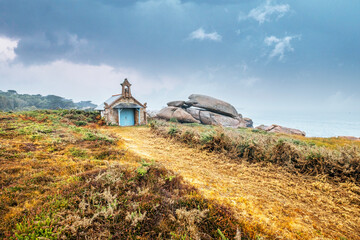 Small church in pink granite coast in Ploumanac'h in Brittany. The Devil's Chapel along the customs...