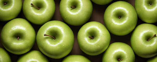 Green apples are laid out next to each other, showcasing their bright colour and fresh appearance in a simple but visually appealing arrangement. Top view.