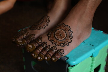 Bangalore, India 9th April 2024: Indian Groom wedding henna mehendi mehndi feet close up. Henna...